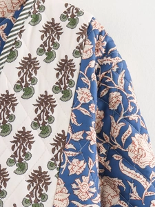 Close-up of diamond quilted jacket with vintage floral patterns and striped trim