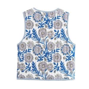 Detail of floral quilted vest showing intricate lavender pattern and blue striped trim edges