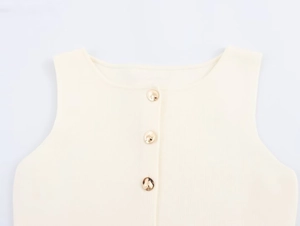 Dettaglio del gilet in maglia bianco crema con costine verticali e bottoni dorati
