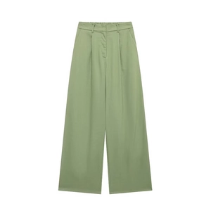 Détail du pantalon large vert clair à taille haute plissée avec une texture fluide