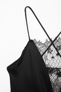 Détails de la dentelle florale noire et du tissu soyeux sur un haut à bretelles