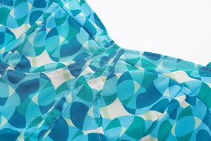 Détail de l'imprimé floral géométrique et des coutures durables sur une robe d'été