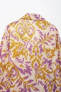 Detail of vintage Baroque floral pattern on off-white linen fabric with gold accents