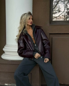 Detail of burgundy leather jacket featuring wide lapels and a metallic zipper closure