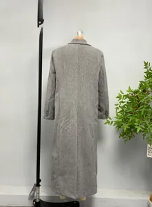 Detail view of the back seams and buttoned cuffs on a long grey wool blend coat