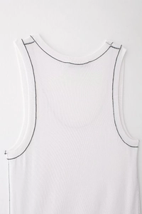 Close-up of white knitted tank top featuring black contrast stitching and ribbed texture