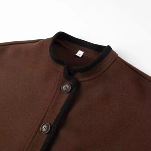 Close-up of brown wool jacket featuring contrast knit trim and round dark buttons