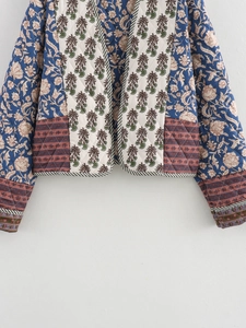 Detail view of quilted jacket featuring mixed bohemian patchwork prints and stripe piping