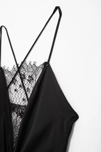 Détail de robe noire à col en V avec des paillettes et une fine bordure en dentelle