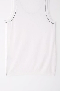 Detail showing white knit vest with black contrast stitching along the armholes and seams