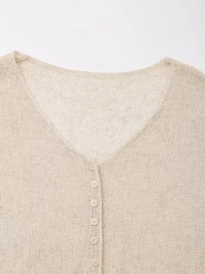 Close-up of V-neck opening and button detail on a beige mesh knit cardigan sweater