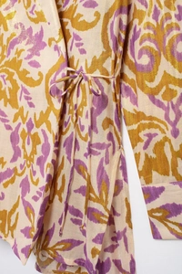 Detail of bohemian print fabric with golden lurex metallic threads and tie-waist closure