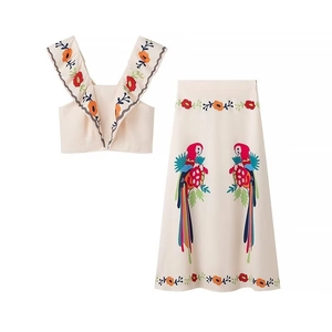 Detail of summer two-piece set featuring ruffled crop top and parrot flower embroidery