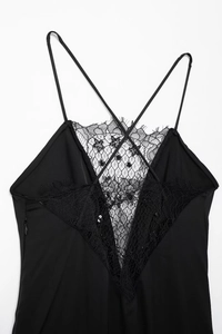 Gros plan sur le patchwork de dentelle noire et la broderie florale de la robe