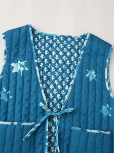 Detail einer gesteppten Wendeweste mit blauem Sternenprint und praktischem Bindeband vorne