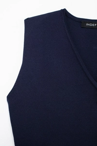 Detail of dark blue V-neck knit vest featuring ribbed edges and high-quality texture