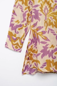 Detail of metallic thread patterns and fine stitching on white floral print shirt