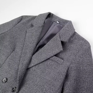 Close-up of a grey wool texture blazer with notch lapels and black button details