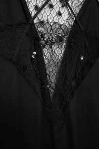 Détail de robe noire avec dentelle florale complexe et paillettes scintillantes