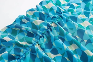 Détail de l'imprimé floral géométrique bleu et vert avec tissu plissé sur robe d'été