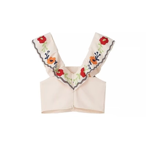 Detail of ruffle straps with colorful floral embroidery on a beige cropped top