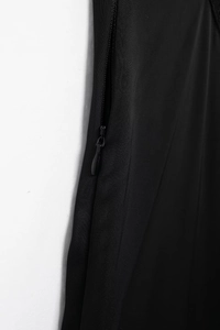 Détail du zip invisible sur le tissu d'une robe d'été noire avec ornements dentelle