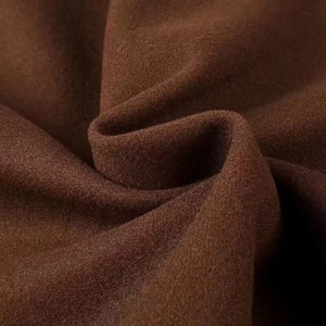 Macro view of dark brown wool coat fabric texture showing thick and soft fibrous surface