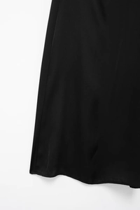 Vue détaillée de l'ourlet de la robe en satin noir avec dentelle élégante et texture lisse