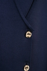 Close-up of luxury gold spherical buttons on navy blue knitted vest with fine texture