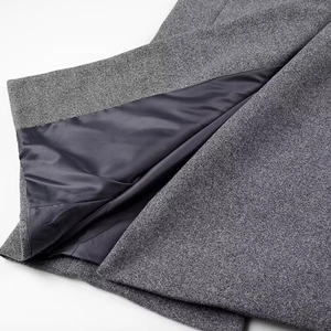 Detailed view of grey wool blend fabric texture with smooth dark satin lining finish