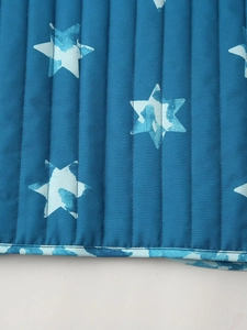 Detail der dunkelblauen Steppweste mit hellblauen Aquarell-Sternmustern für Damen