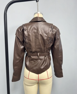 Détail du dos d'une veste en similicuir marron avec laçage décoratif et ceinture à la taille