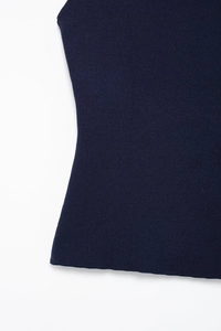 Detail of navy blue knitted vest showing vertical ribbed texture and slim waist tailoring
