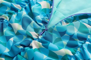 Gros plan détaillé sur la fermeture éclair violette d'une robe bleue à motifs variés