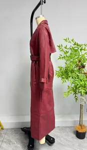 Détail d'un long trench-coat en cuir rouge foncé avec ceinture et col à revers élégant