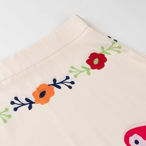 Detailed close-up of vibrant floral print on soft cream fabric with ruffle texture