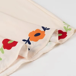 Detailed macro view of the light floral print pattern on layered ruffle fabric edges