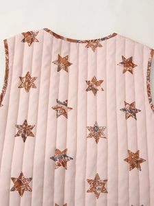 Detailansicht der gesteppten Weste in Rosa mit Sternenmuster und floralem Saum