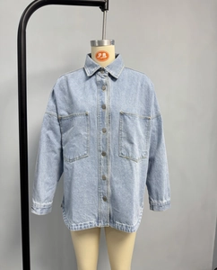 Close-up of light blue washed denim jacket with cargo pockets and metallic buttons