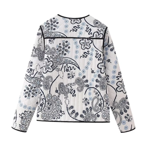 Detail view of the back of a quilted paisley print jacket with black trim and diamond seams