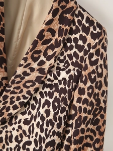 Detailed close-up of leopard print blazer showing the collar and chest pocket texture