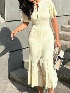 Dettaglio dell'abito in maglia bianco avorio con trama a coste e bottoni eleganti