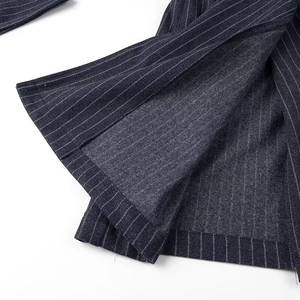 Détail du manteau à rayures avec fente latérale et coutures intérieures professionnelles