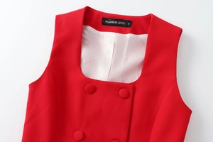 Dettaglio di top smanicato rosso con scollo quadrato e bottoni rivestiti in tessuto
