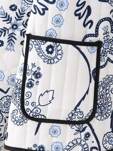 Detail of white quilted jacket with blue floral patterns and black trim pocket