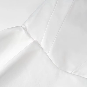 Dettaglio del tessuto in raso bianco che mostra la trama lucida e le cuciture di qualità