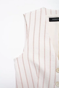 Close-up of beige pinstripe vest with V-neckline and textured buttons on linen fabric
