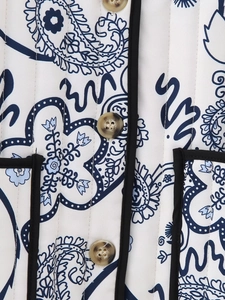 Detailed macro view of paisley pattern quilting and marble texture buttons on the coat