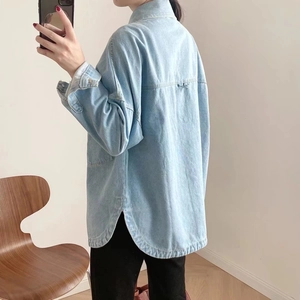 Back view of women's oversize light blue washed denim jacket with curved hem design