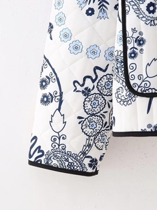 Close-up of quilted floral jacket with blue paisley patterns and black trim detail